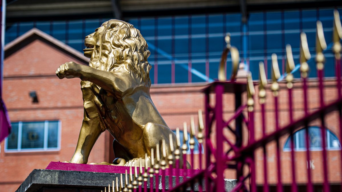 gilded lion statue outside a ground
