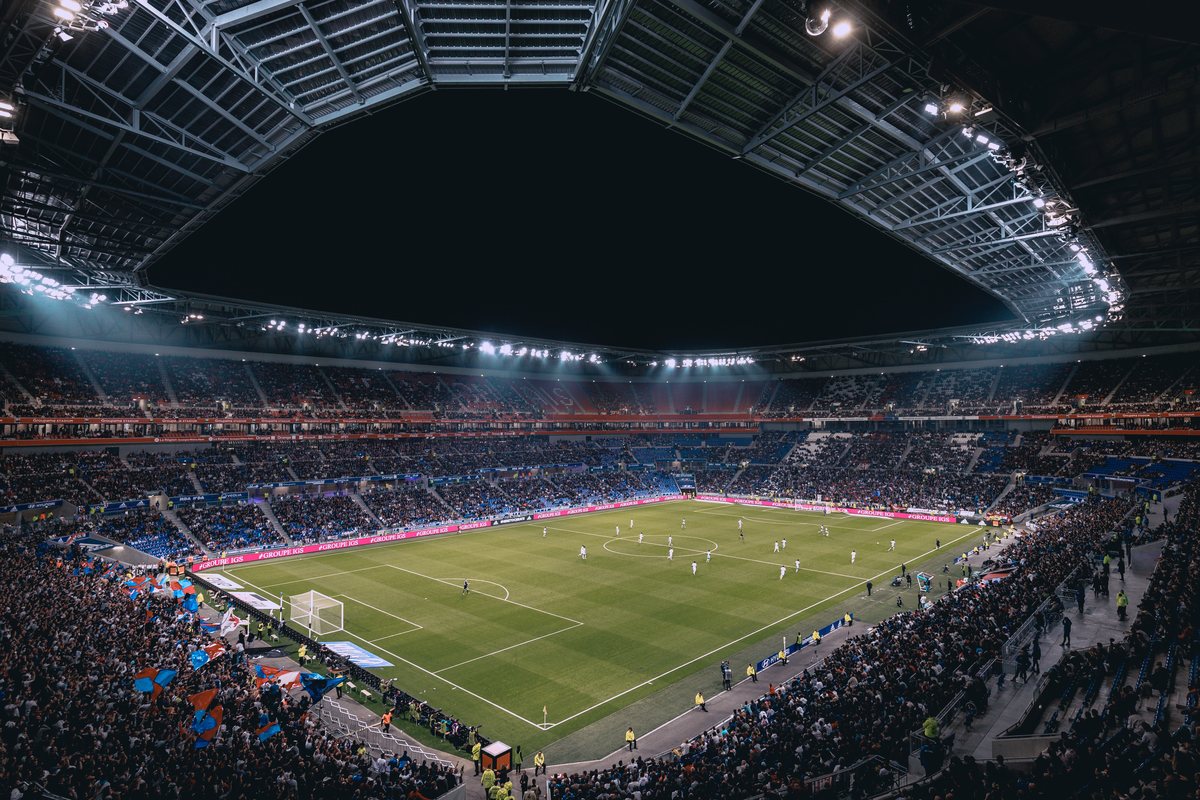 The Gamechanger logo over a floodlit stadium packed for a night match, seen from high in the stand