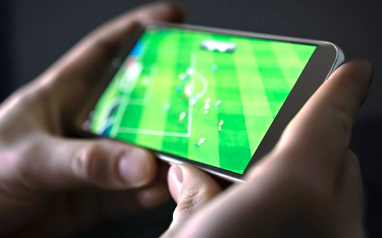 hands holding a phone showing a match in progress