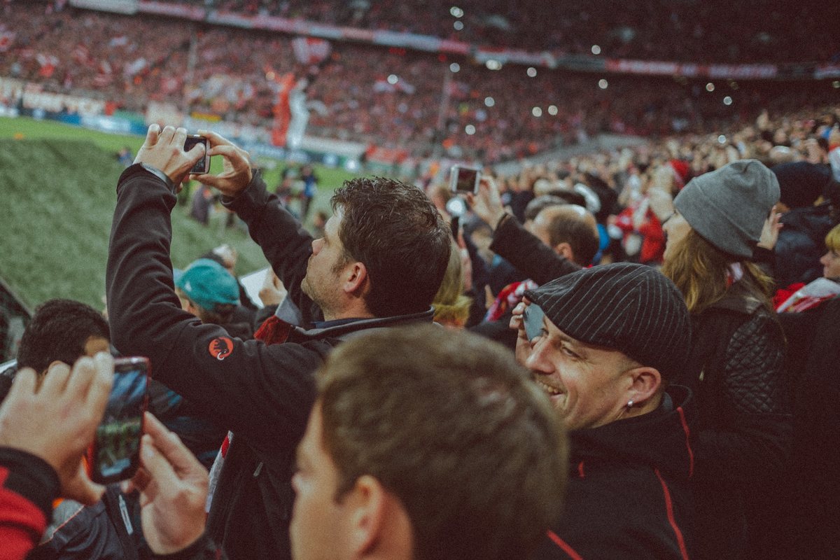 supporters in a stand photographing the pitch on their phones